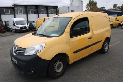 La camionnette jaune est garée sur un parking, à côté d'autres véhicules.