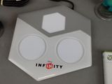 a white electronic device sitting on a table next to a game controller