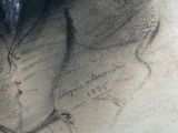a drawing of a woman ' s face in the sand