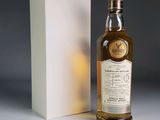 a bottle of whisky sitting next to a box on a table