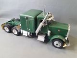 a toy truck that is green and white on the table