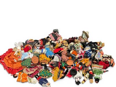 a pile of assorted dolls on a white surface