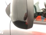 a reflection of a man in the side view mirror of a car