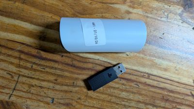 a usb drive next to a bottle of water on a table