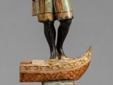 statue d'un homme tenant une épée, posée sur une caisse en bois