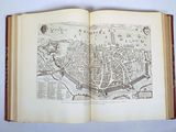 an open book with a drawing of a city on it