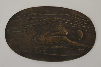 une plaque ovale en bronze avec un chien au centre
