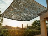 an image of a patio with a table and chairs under a sun shade