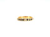 un gros plan d'une bague en or sertie de diamants noirs sur fond blanc