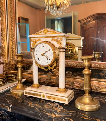 a clock that is sitting on a table in front of a mirror