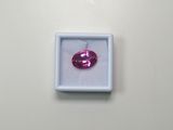 a close up of a pink diamond in a white box