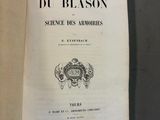 un livre ouvert sur lequel figure une image en noir et blanc représentant des armoiries