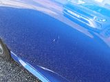 a close up of a blue car parked on the side of the road