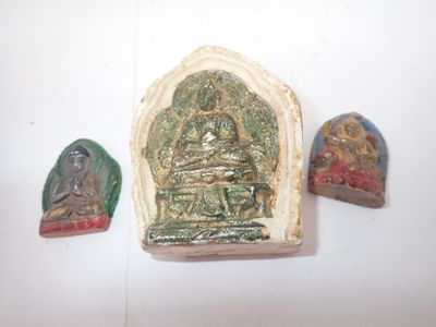 trois petites œuvres d'art sont exposées sur une surface blanche