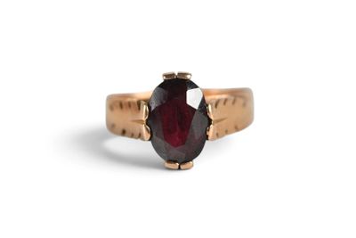 a close up of a gold ring with a red stone