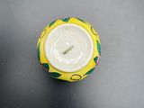 a small yellow and green bowl on a black table