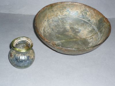 a metal bowl and a glass vase sitting on a table