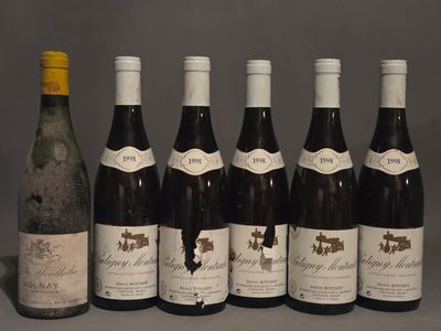 six bouteilles de vin sont alignées sur une table