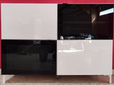 a black and white cabinet with a red wall behind it