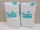 two packs of pampers baby dry diapers sitting on top of each other