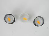 three cups of water with orange pills in them on a white surface