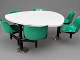 une table blanche entourée de quatre chaises vertes