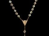 a gold necklace with a long chain and a cross on it