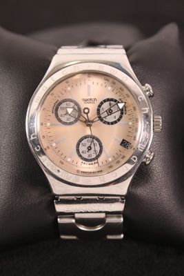 silver watch on a black cushion on a black surface