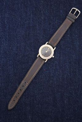 a close up of a watch sitting on top of a pair of jeans