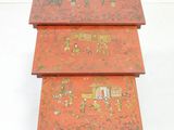 three red nesting tables with gold designs on them against a white background