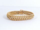 un bracelet en or avec un motif de tresse sur fond blanc