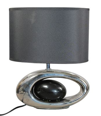 lampe de table argentée avec un abat-jour noir sur fond blanc