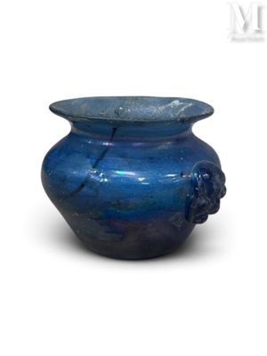 un vase bleu posé sur une surface blanche