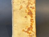 an old book sitting on top of a table next to a black table