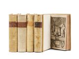 several old books sitting on top of each other on a white surface