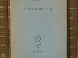 un livre posé sur une étagère, devant une pile de livres
