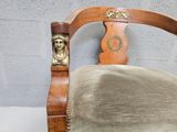 a wooden chair with a head on the back of it