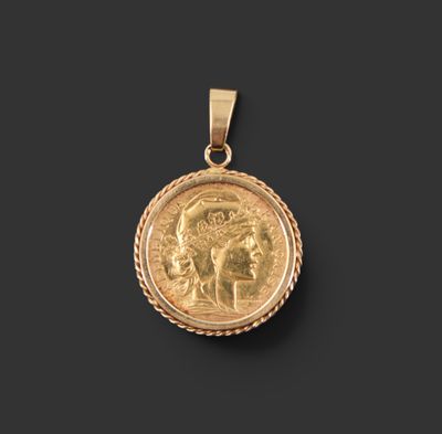 un pendentif en forme de pièce d'or sur lequel est gravé le portrait d'une femme