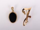 an image of two gold and black pendants on a white background
