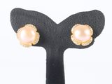 a pair of pink pearl and diamond earrings on a black stand