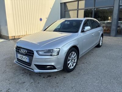 Une Audi argentée est garée devant un immeuble