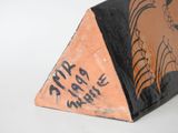 a small triangular shaped object with a drawing on it