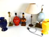 a lot of different colored vases and lamps on the table