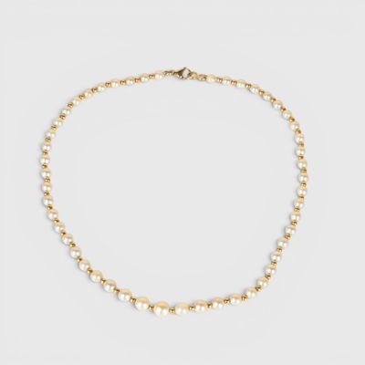 un collier de perles dorées sur fond blanc