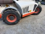a white and orange tractor parked in a parking lot