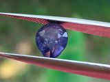 un gros plan d'un diamant bleu tenu par une pince