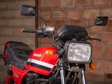a red motorcycle parked in front of a brick wall