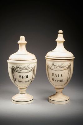 deux vases blancs posés l'un sur l'autre sur une table