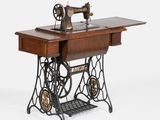 une vieille machine à coudre posée sur une table en bois