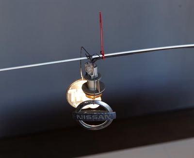 une clé de voiture suspendue à un fil et portant le logo Nissan